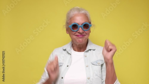 Happy senior woman in sunglasses having fun dancing