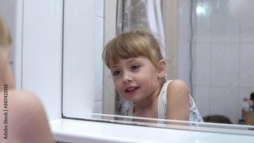 Girl washing her face in front of the mirror in the bathroom Girl washing her face in front of the mirror in the bathroom