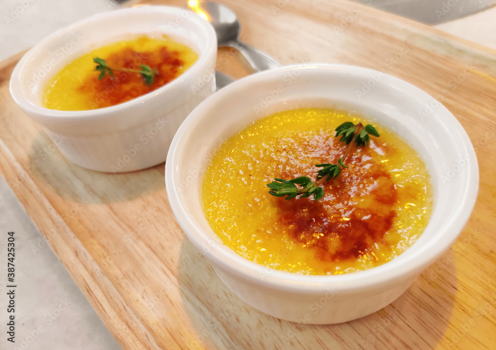Close up of creme brulee dessert with caramelized sugar on top, on wooden table. Traditional French dessert Close up of creme brulee dessert with caramelized sugar on top, on wooden table. Traditional French dessert