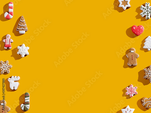 Orange Xmas advertising background. Greeting card. Homemade gingerbread cookie pattern decorative frame. Colorful fun dessert collection festive composition for kids isolated on bright yellow empty