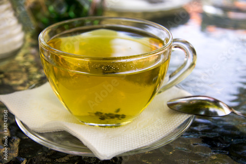 Cup of herbal tea in transparent cup outdoors