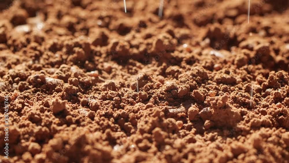 Slow motion of water drops falling and splashing onto ground coffee, cocoa beans Slow motion of water drops falling and splashing onto ground coffee, cocoa beans