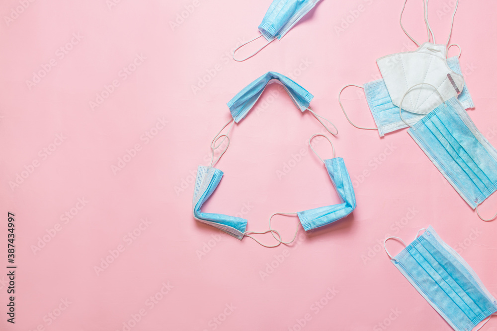 Recycle sign made from used medical mask. Throws a medical mask into the recycling box concept. Blue face masks after use. Medical masks utilizing Recycle sign made from used medical mask. Throws a medical mask into the recycling box concept. Blue face masks after use. Medical masks utilizing