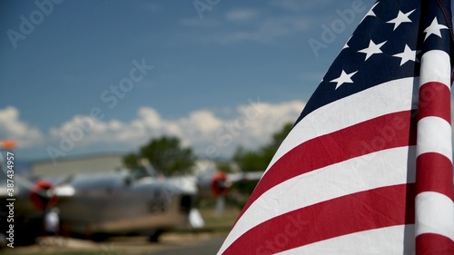 American flag waving to the wind with old airplane in the background