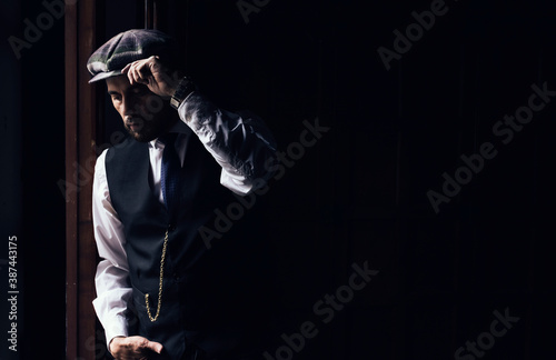 Man in twilight with beret looking out a window