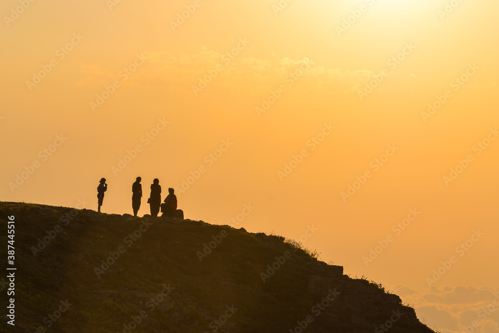 People silhouettes at sunset in the highlands