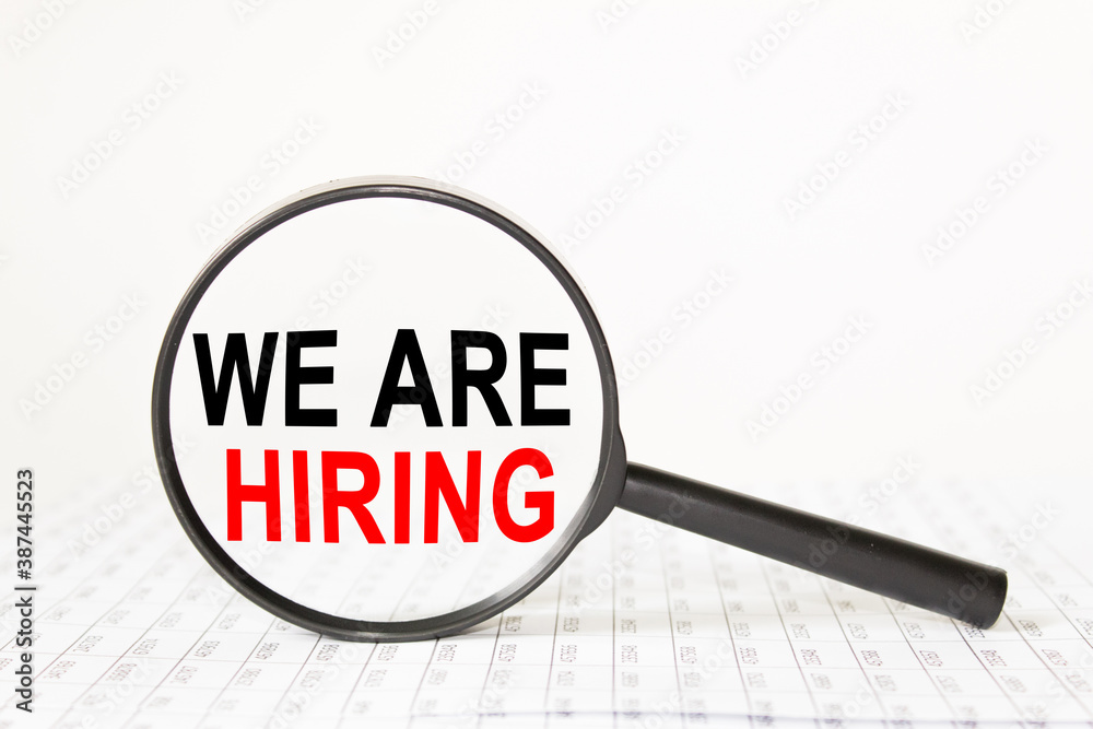 text WE ARE HIRING in a magnifying glass, office concept, business concept, Finance text WE ARE HIRING in a magnifying glass, office concept, business concept, Finance