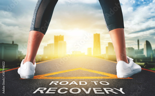 Fotografija Woman leg standing on Road to recovery concept for business and health concept with golden city background