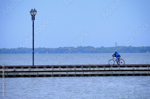 Man on a bicycle in a marina with lamppost