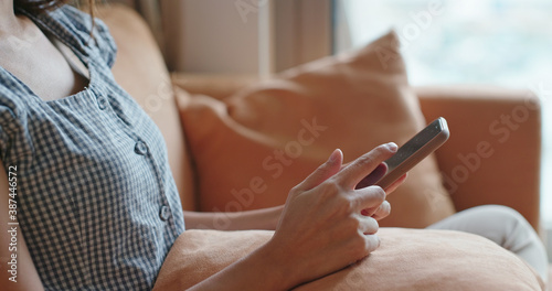 Woman use of mobile phone and sit on sofa
