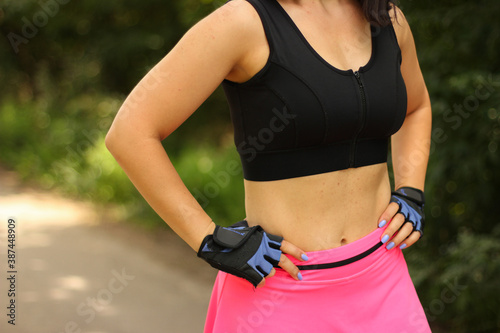 a girl in a sports uniform shows her abs in the summer on the street