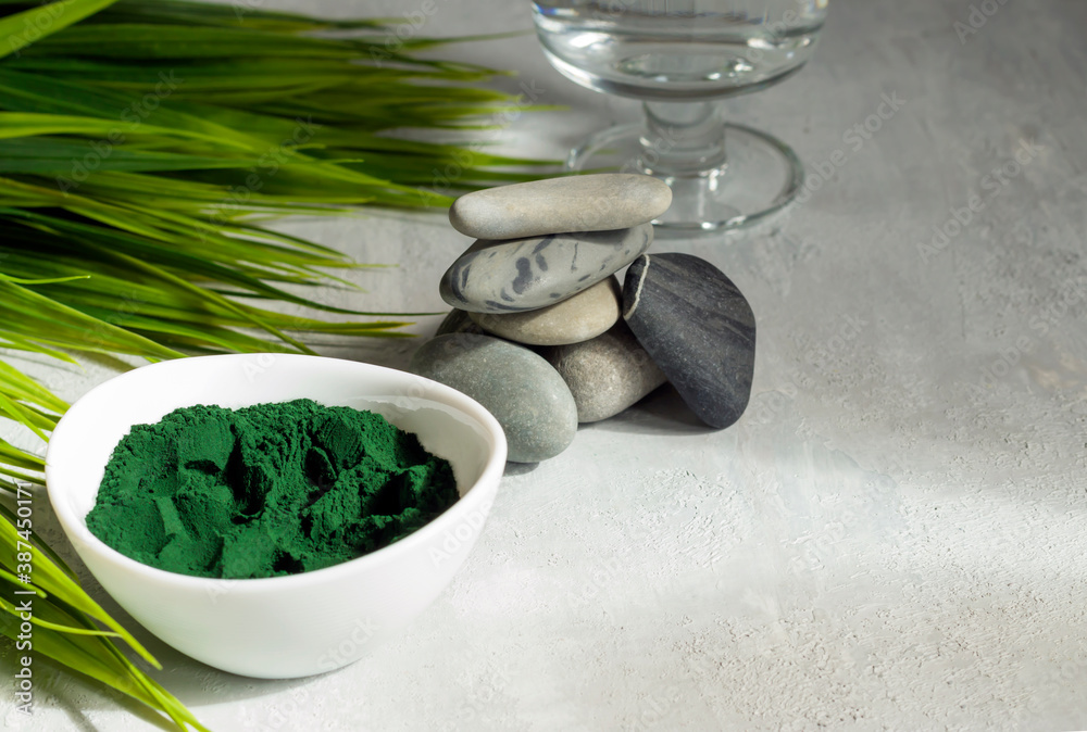 Spirulina powder on a light background. Healthy food supplement for vegan, vegetarian or plant based diets. SPA procedures.Contains multivitamins Spirulina powder on a light background. Healthy food supplement for vegan, vegetarian or plant based diets. SPA procedures.Contains multivitamins