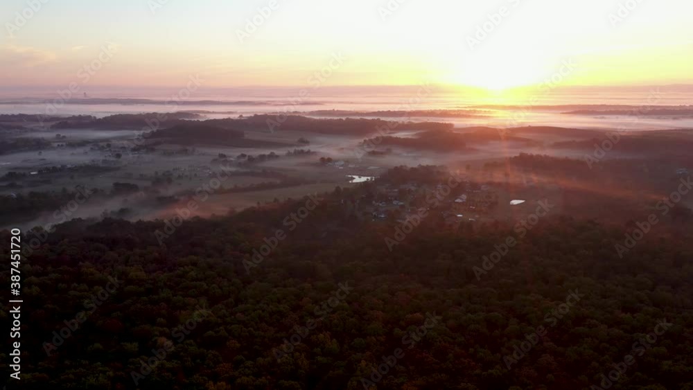 Aerial turning view of sunrise over a rural West Virginia countryside with fog settling in the valleys. Aerial turning view of sunrise over a rural West Virginia countryside with fog settling in the valleys.