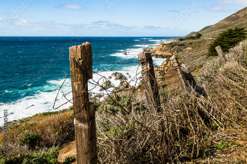 Rustic tangled barbed wire fence on the coast of Big Sur