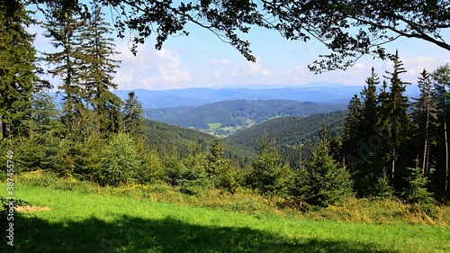 Scenic view of Javorníky mountains on Czech and Slovak border during sunny summer day. Mostly coniferous forests are visible, partially cloudy skies. Photo taken near Kohutka ski resort. 