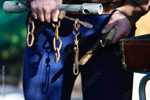Man's hands holding of different kind vintage working tools in the garden at sun summer day
