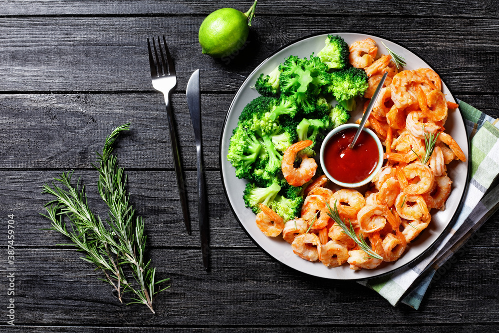 Fototapeta premium Garlic butter prawns with broccoli, top view