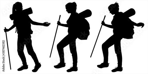 Girl with a backpack behind her back and a tourist rug on the backpack. Woman steps carefully and holds a walking stick in her hand. Hiking. Three black female silhouettes isolated on white background