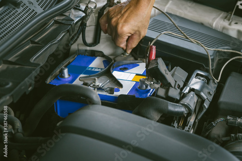 Engine engineer is replacing car battery because car battery is depleted. concept car maintenance And the cost of car care.