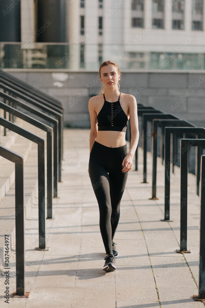 Stylish fit woman in sport outfit walking on sport square. Attractive  sportswoman, enjoying summer, training, outwork, happiness Stock Photo |  Adobe Stock