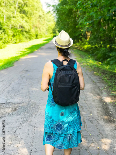 A Woman Walks Along the Road in the Forest