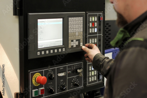 Work on the control panel of machine CNC. Cutting metal modern processing technology.