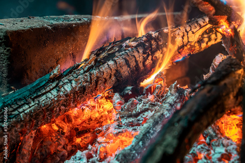 Logs burn in a fire. Charred sticks.