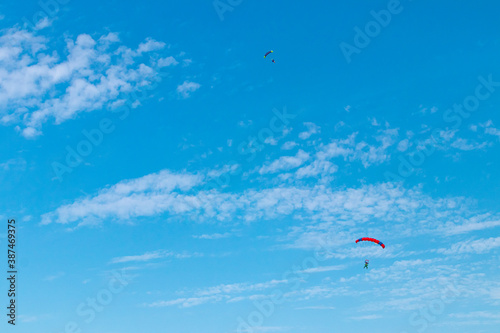 Parachutist is flying in the sky, sunny contrast image.