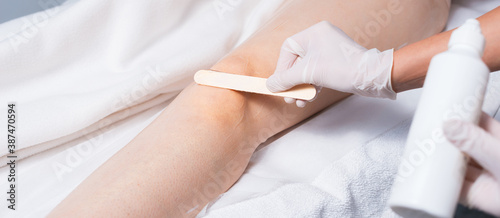 Close up photo of woman leg preparing with wax before laser hair removal