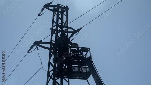 Electrician checking fixing broken electric wire on pole.
