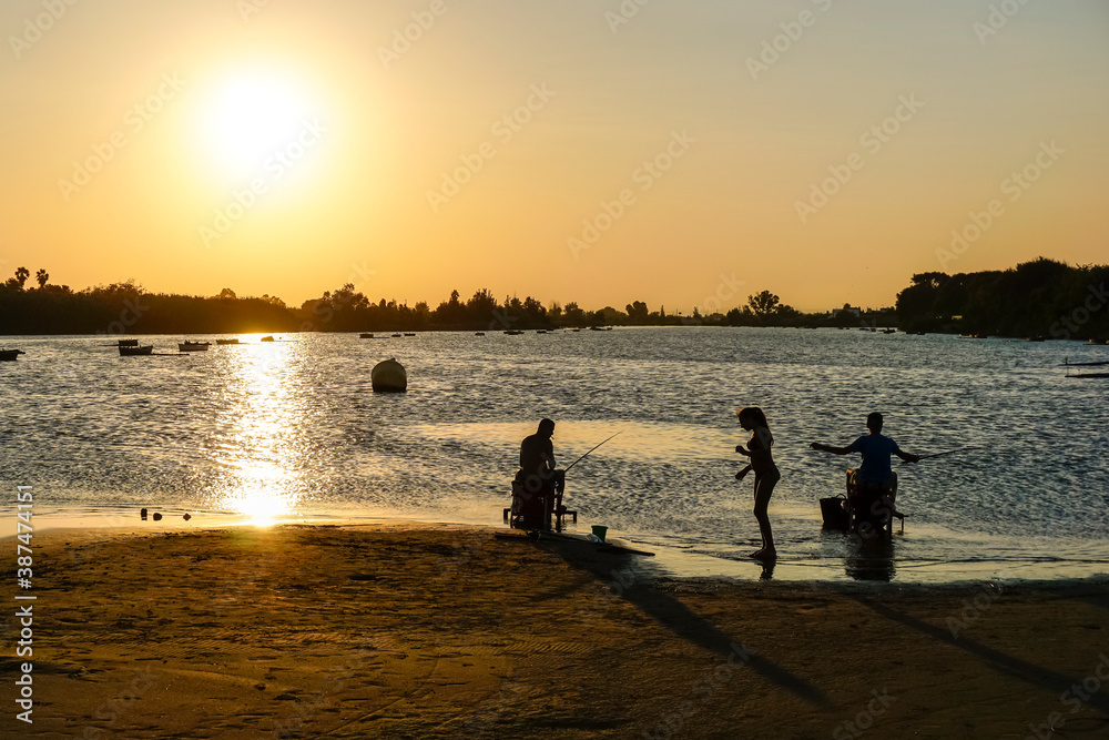 people fishing in the lagoon at sunset