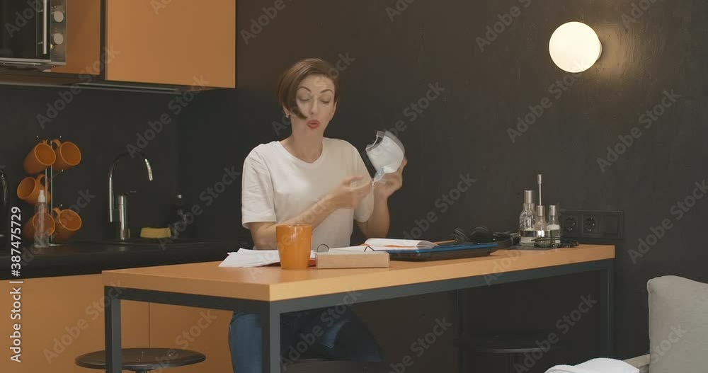 Tired young businesswoman closing laptop and taking off Covid-19 face mask. Portrait of exhausted female Caucasian CEO working online during coronavirus pandemic. Covid lifestyle.