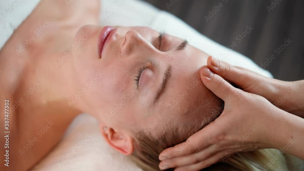 Woman masseur makes face relaxing massage to young beautiful female client blonde and spa treatment for perfect skin in beauty salon. Cosmetology services. Skin and body care and Healthcare. Close-up Woman masseur makes face relaxing massage to young beautiful female client blonde and spa treatment for perfect skin in beauty salon. Cosmetology services. Skin and body care and Healthcare. Close-up