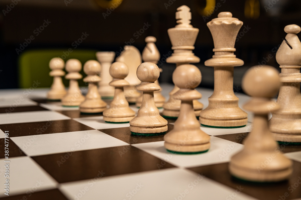 Play wooden chess on a platform in a brown cage, pawns and rooks, queens and kings, horses table in the dark, stylish for advertising design. Play wooden chess on a platform in a brown cage, pawns and rooks, queens and kings, horses table in the dark, stylish for advertising design.