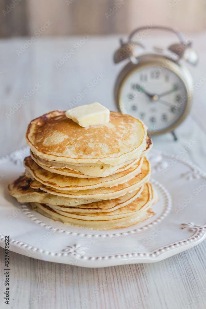 stack of pancakes, light morning, alarm clock in the background, light background stack of pancakes, light morning, alarm clock in the background, light background