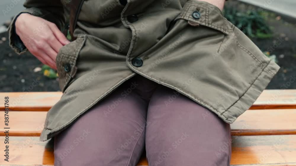 Close-up of a seated man with his hands patting and checking pockets in search of phone. The gadget will find for urgent business correspondence. Outdoors. Close-up of a seated man with his hands patting and checking pockets in search of phone. The gadget will find for urgent business correspondence. Outdoors.