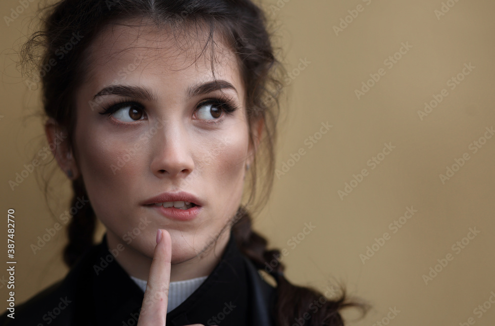Portrait of a beautiful thoughtful girl on a beige background Portrait of a beautiful thoughtful girl on a beige background