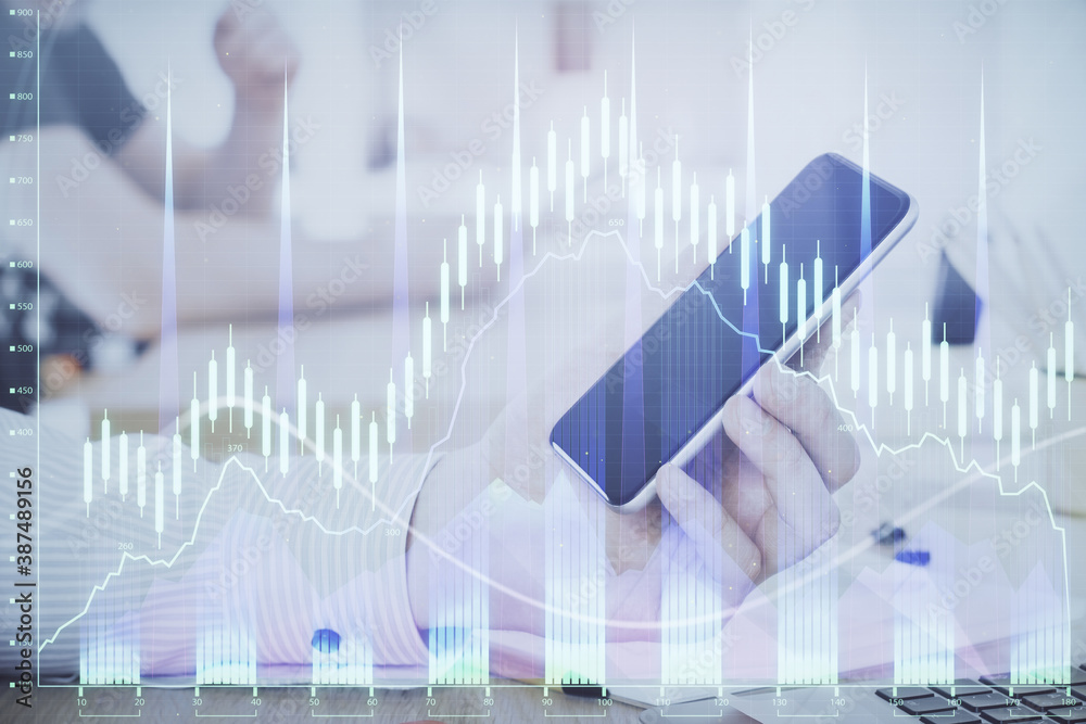 Double exposure of man's hands holding and using a digital device and forex graph drawing. Financial market concept. Double exposure of man's hands holding and using a digital device and forex graph drawing. Financial market concept.