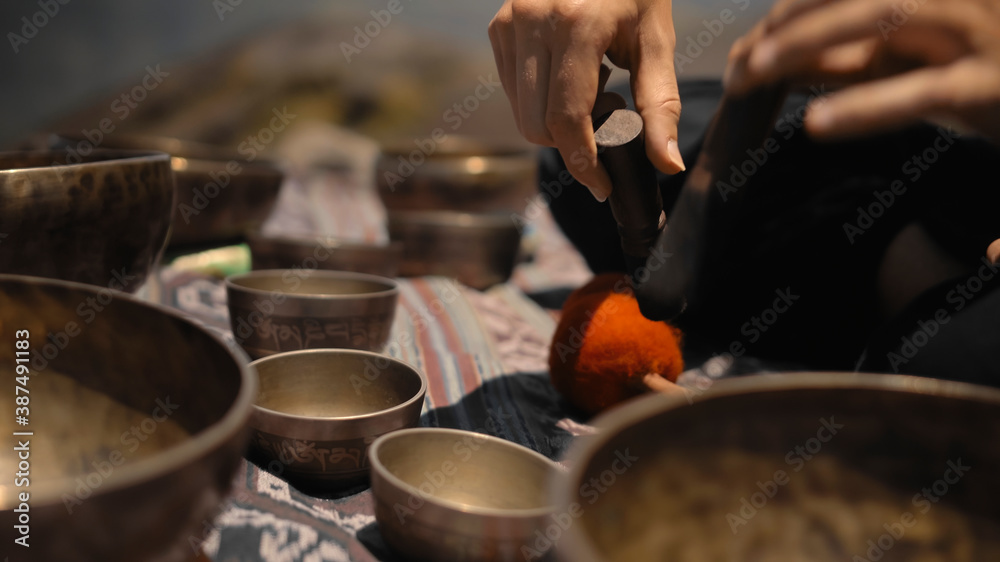 Asian guy playing Tibedt singing copper cups on a viewing mountain Asian guy playing Tibedt singing copper cups on a viewing mountain