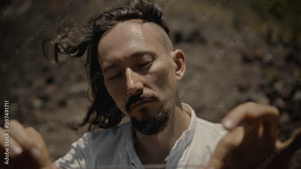 Fototapeta premium Asian guy playing Tibedt singing copper cups on a viewing mountain
