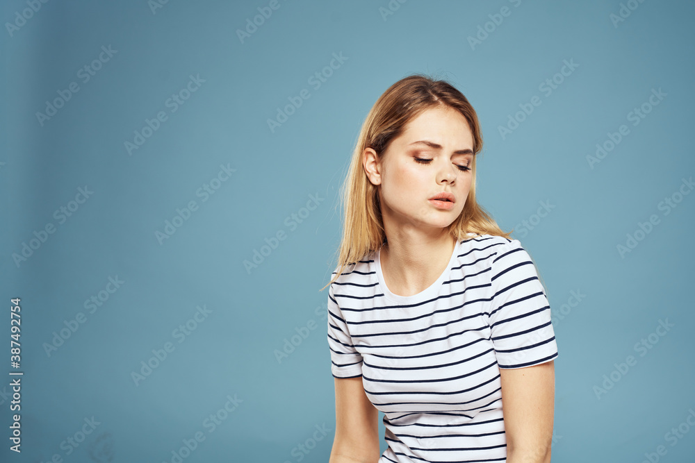 Emotional woman striped t-shirt lifestyle cropped blue background Emotional woman striped t-shirt lifestyle cropped blue background