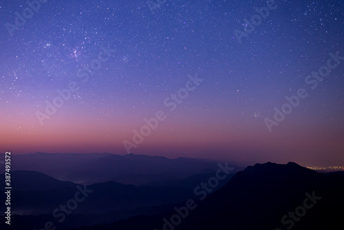 Night landscape with colorful star and milky way and beautiful twilight sky before sunrise over the mountain.