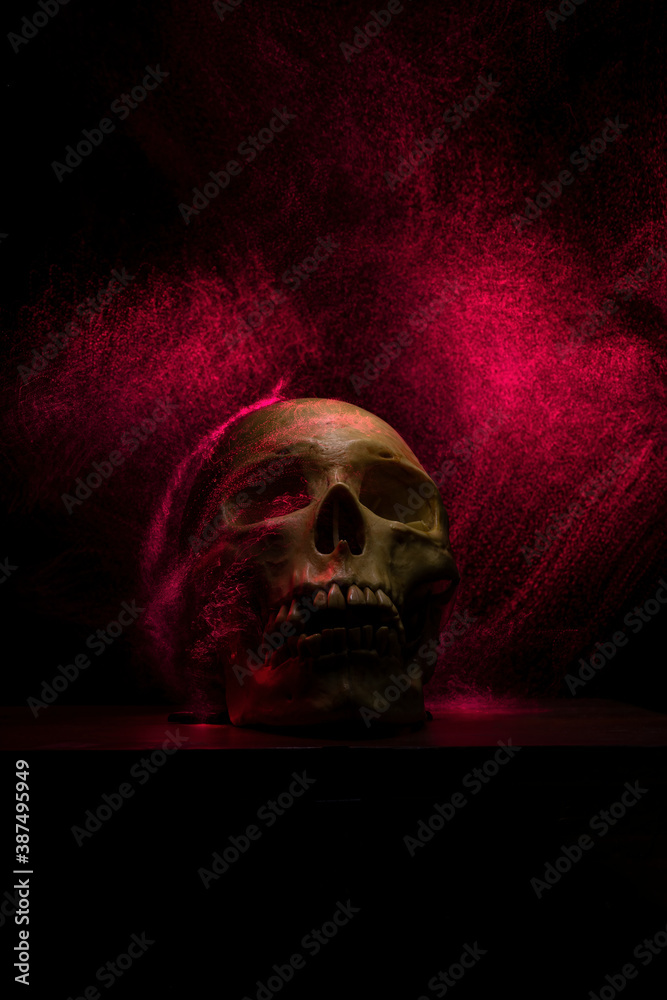A human skull light painted with red led lights on a dark black background expressing a feeling of horror