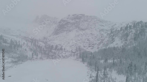 Beautiful Mountain Landscape View of White Puffy Snow Covered Raduzhnoe Lake during winter day. Located Nature Park Ergaki, Krasnoyarskiy krai, Russia. High quality 4k footage photo