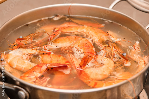 Red prawns are cooked in a metal pot.