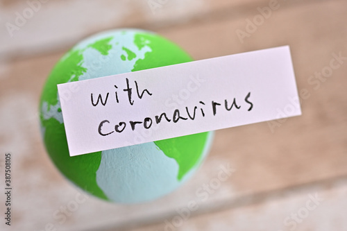 There is an earth ball and a sticky note that says "with Coronavirus".