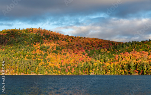 Foliage in Vermont. Multicolor trees on the hills by the lake