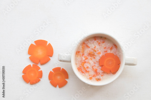 mix rice gruel and carrot healthy foods health care for baby eats breakfast  decoration flat lay style on background white 