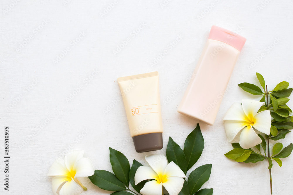 natural cosmetics for skin face sunscreen spf50 ,body lotion health care surface and flower frangipani decoration flat lay style on background white natural cosmetics for skin face sunscreen spf50 ,body lotion health care surface and flower frangipani decoration flat lay style on background white