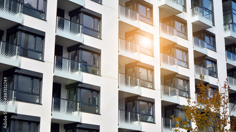Modern and new apartment building. Multistoried modern, new and stylish living block of flats. Facades on a bright sunny day with sunbeams in the blue sky. Modern and new apartment building. Multistoried modern, new and stylish living block of flats. Facades on a bright sunny day with sunbeams in the blue sky.